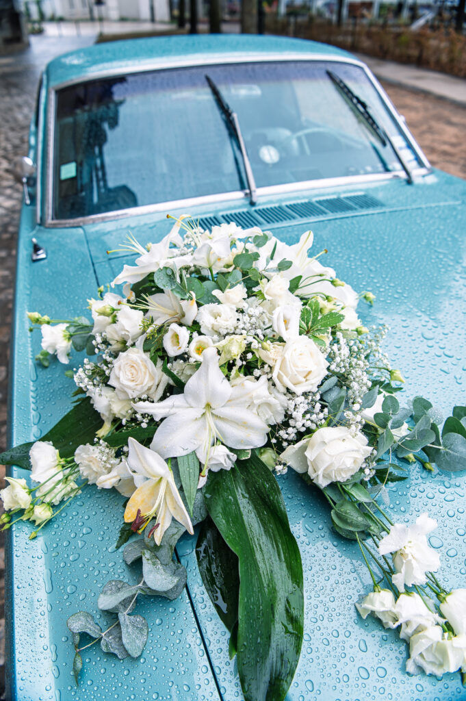 Mustang verte voiture de mariés avec bouquet de fleurs blanches